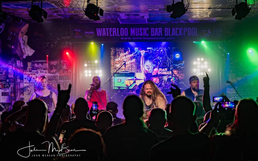 Ey Up Maiden band members performing live